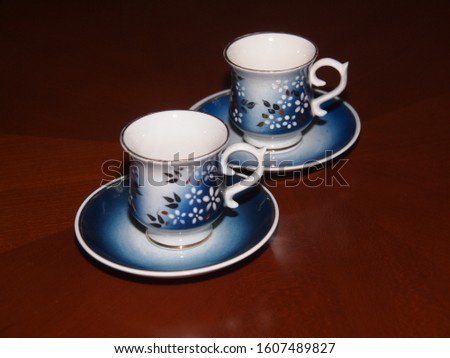 Photo of the decorative porcelain cups and plates  on the table