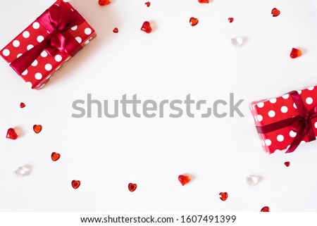 The Background Of Valentine's Day. Gifts with bows, confetti, rhinestones, glass hearts on a light background. The Concept Of Valentine's Day. Flat lay, top view, copy space