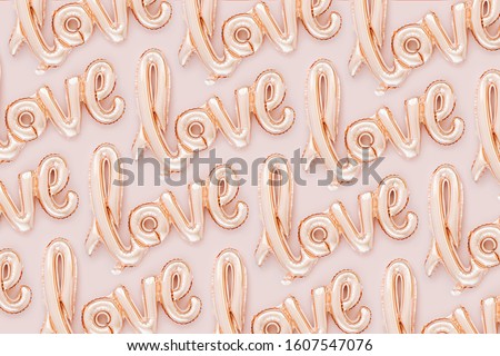 Pale pink Foil Balloons in the shape of the word "Love" on pastel background. Love concept. Holiday, celebration. Valentine's Day or wedding/bachelorette party decoration.  