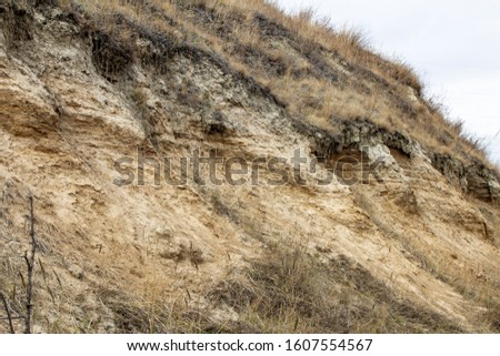 natural photo of a cut of a layer of earth and clay on a cliff