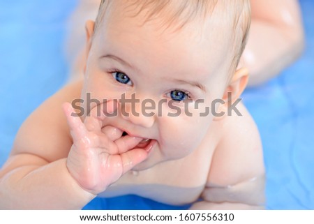 Cute happy baby taking a bath and playing