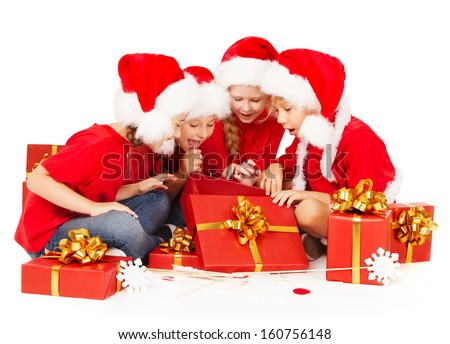Christmas kids in Santa hat opening red gift box. New year presents over white background.