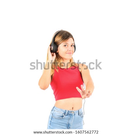 Happy blonde teenager girl doing a two finger gesture with her hand while wearing headphones against a white background