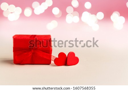 Two red hearts and red gift box on a white background with lights. Valentines day, love, romance, dating, gift present, anniversary concept with Copy space. Stock photo Valentine day card