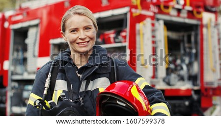 Close up photo of Female firefighter in protective suit with oxygen mask and helmet in her hands