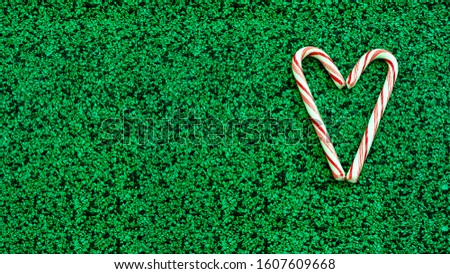 candy  decorate heart shape on green background.