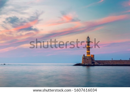 Venetian harbour and lighthouse in old harbour of Chania at sunset, Crete, Greece. Old venetian lighthouse in Chania, Greece. Lighthouse of the old Venetian port in Chania, Greece. Royalty-Free Stock Photo #1607616034