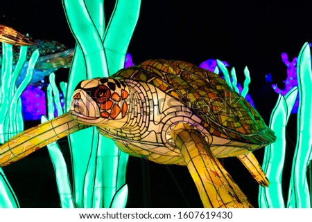Neon turtle in a Parisian garden at night time