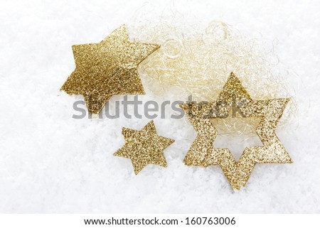 christmas, golden christmas stars on artificial snow 