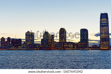 Night Jersey City, New Jersey and Hudson River. View from Manhattan, New York of USA. Cityscape with skyscrapers at United States of America, NYC, US. Road and American architecture. Mixed media.