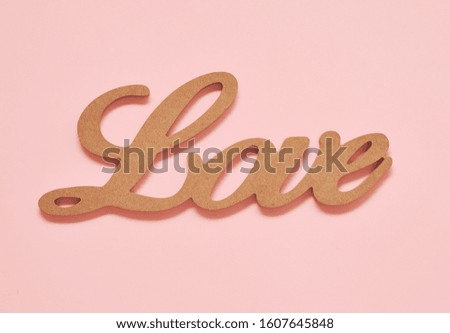 Wooden word Love on pink background.