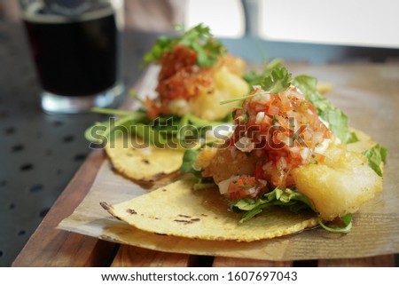 Fried Shrimp Taco with Cilantro and Salsa with Beer in Background