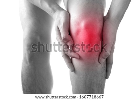 Black and white picture .Knee pain .man stand hand caught at the knee.  health concepts