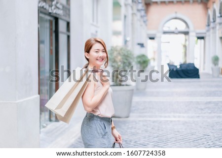 Smiling Asian Thai girl holding gift in shopping bags