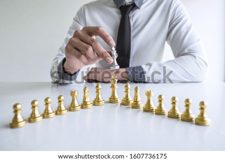 Gold and silver chess with player, Hands of businessman moving chess figure in competition to planning strategy to success play for win.