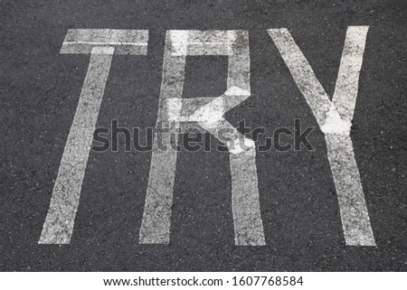 Painted lines on the asphalt road with the word TRY, perseverance and persistence message