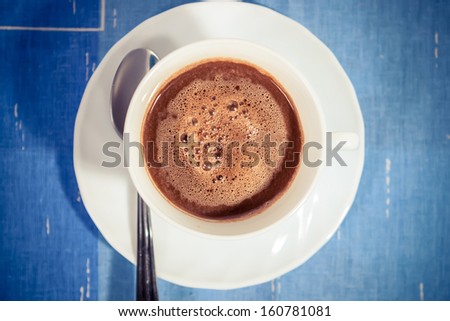 Hot coffee with froth in white mug