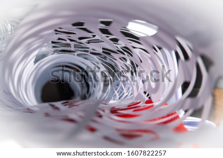 Rolled intricate homemade Christmas decoration cut from white paper in a receding abstract background view with selective focus