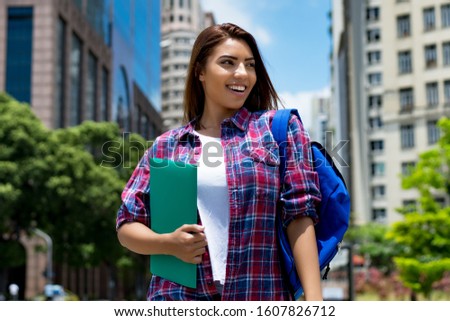 Beautiful hispanic female student in city in summer