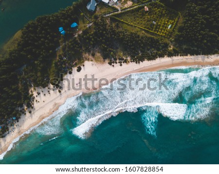 Top view aerial photo from drone of an stunning beautiful sea landscape beach with turquoise water with tree and cottage. Beautiful Sand beach with turquoise water and waves, aerial UAV drone shot.