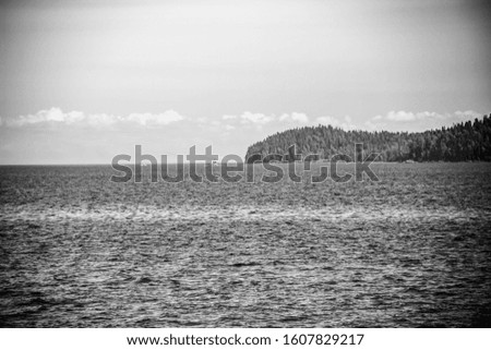 A black and white shot of land and sea meeting point