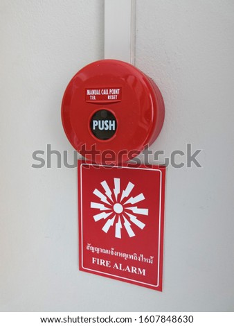 Fire Alarm Equipment. Red manual call point for Fire alarm on the wall with label description (with Thai text) and icon symbol.