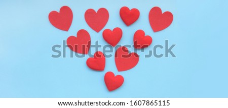close up of red paper hearts on blue background
