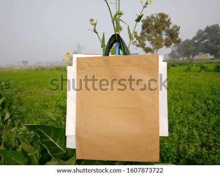 amazing Non Woven eco brown color Bags hanging with green plant. Reusable bags, Shopping & Gift Bags, Environment Friendly Concept. Reduce, Reuse, Recycle
