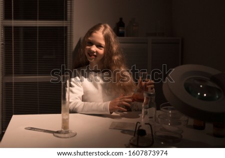 cute teen girl sitting at a table in the lab