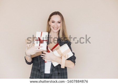 Woman rejoicing at gift received on beige background

