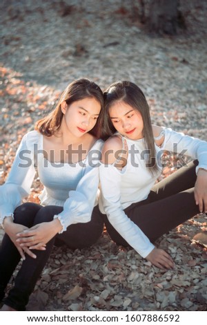  Two Twin teenage girls young woman laughting and having fun near the garden at sunset time