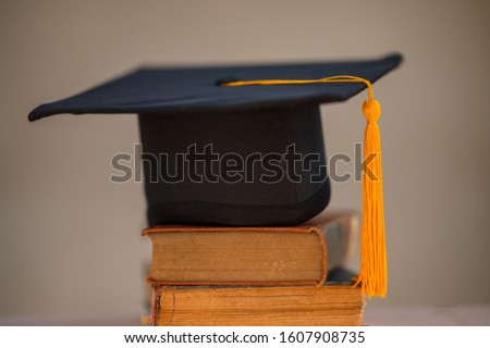 The black hat and golden tassels of the graduates put on the book.