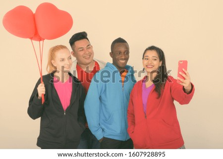 Diverse multi ethnic group of happy friends taking selfie and ready for Valentine's day together