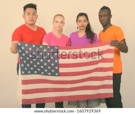 Studio shot of diverse group of multi ethnic friends holding the American flag together
