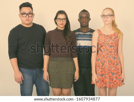 Studio shot of diverse group of multi ethnic friends wearing eyeglasses together