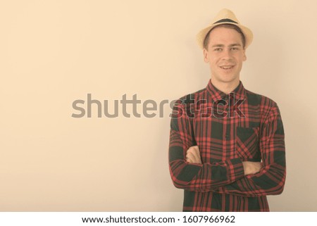 Young handsome tourist man wearing hat against white background