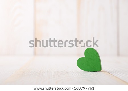 Wooden colored heart ot the wooden background.