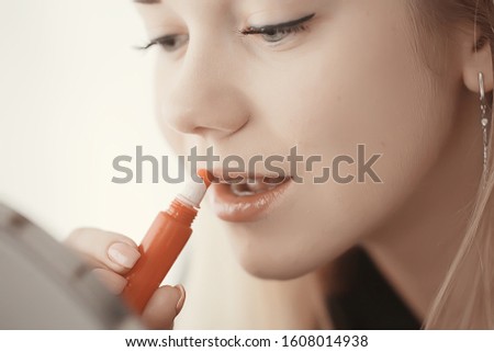 makeup lipstick, a young girl paints her lips, the concept of glamor, fashion, beauty, cosmetics