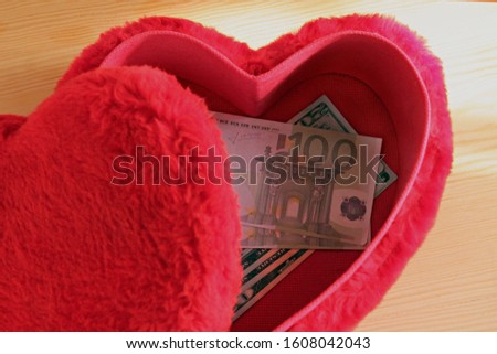 Euro and American Dollar Banknotes in red heart shaped box.Conceptual image of Valentine Day or any special day.