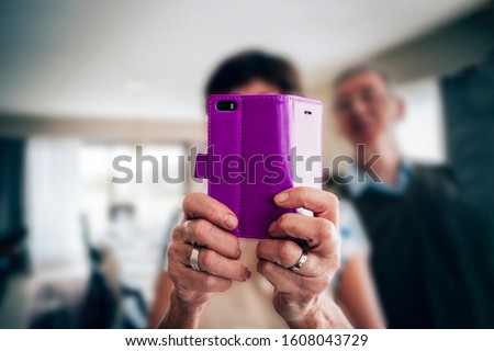older people and technology concept - close up on the hands of an elderly woman taking a picture using a mobile phone