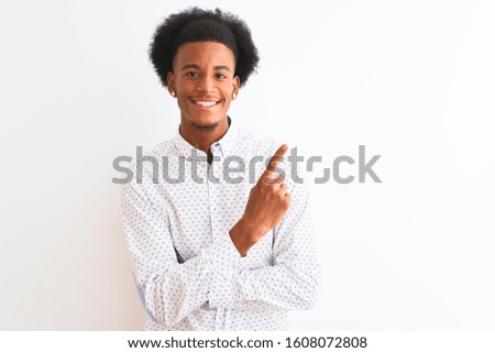 Young african american man wearing elegant shirt standing over isolated white background with a big smile on face, pointing with hand and finger to the side looking at the camera.