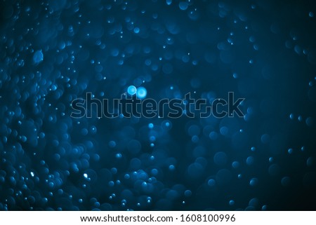 Abstract bokeh lights with blue and black background. Beautiful bokeh from water droplets.
