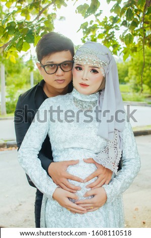 muslim couple when wife pregnant wearing muslim clothes