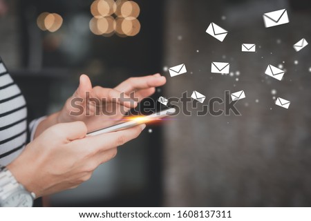 Woman hand using smart phone at coffee shop with email icon flying abstract. Technology business and freelance concept. Vintage tone filter effect color style.