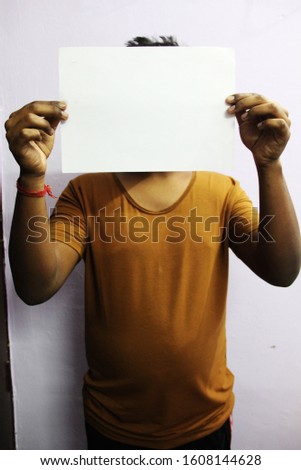 Black man hands holding white blank paper. Close up hands man holding behind a paper blank for banner on gray background.
