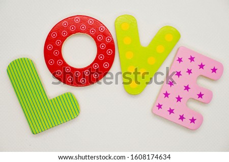 Learning to write and read. Valentine theme. Colored wooden letters L O V E.