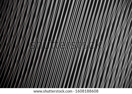 Technological metal grid structure with slots. Abstract black and white background of industry, technology or modern architecture. Geometric composition with diagonal pattern of parallel lines.