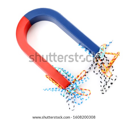 Magnet attracting paper clips on white background, top view