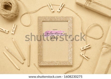 Mockup photo frame with kraft present boxes for Valentines day concept. Top view of mock up photo frame with craft decoration and on wood background. Flat lay top view with copy space.