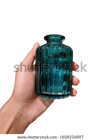Hand holding beautiful green glass bottles isolated on white background.